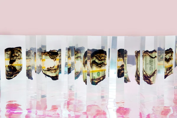 A group of transparent prism sculptures against a pink background.